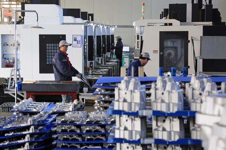 High-precision CNC machining factory with operators working on automated equipment.