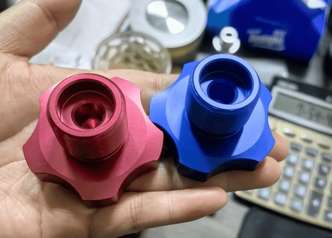 Precision CNC machined aluminum parts in red and blue for industrial applications.