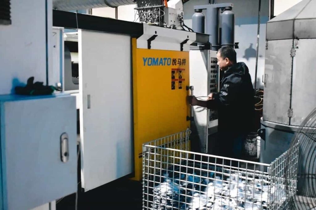 Yamoto CNC machine operating in manufacturing facility with worker adjusting controls.