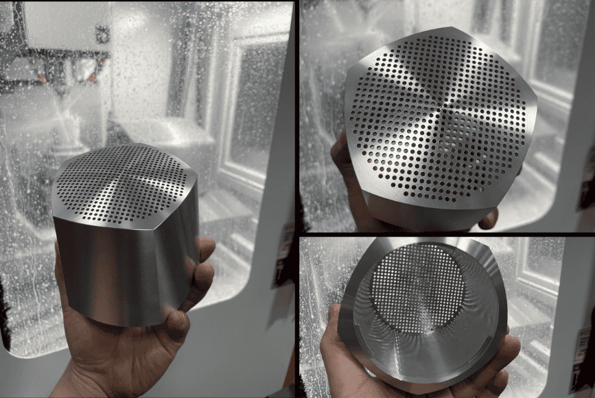 Aluminum CNC machined part with perforated surface and precise circular holes.