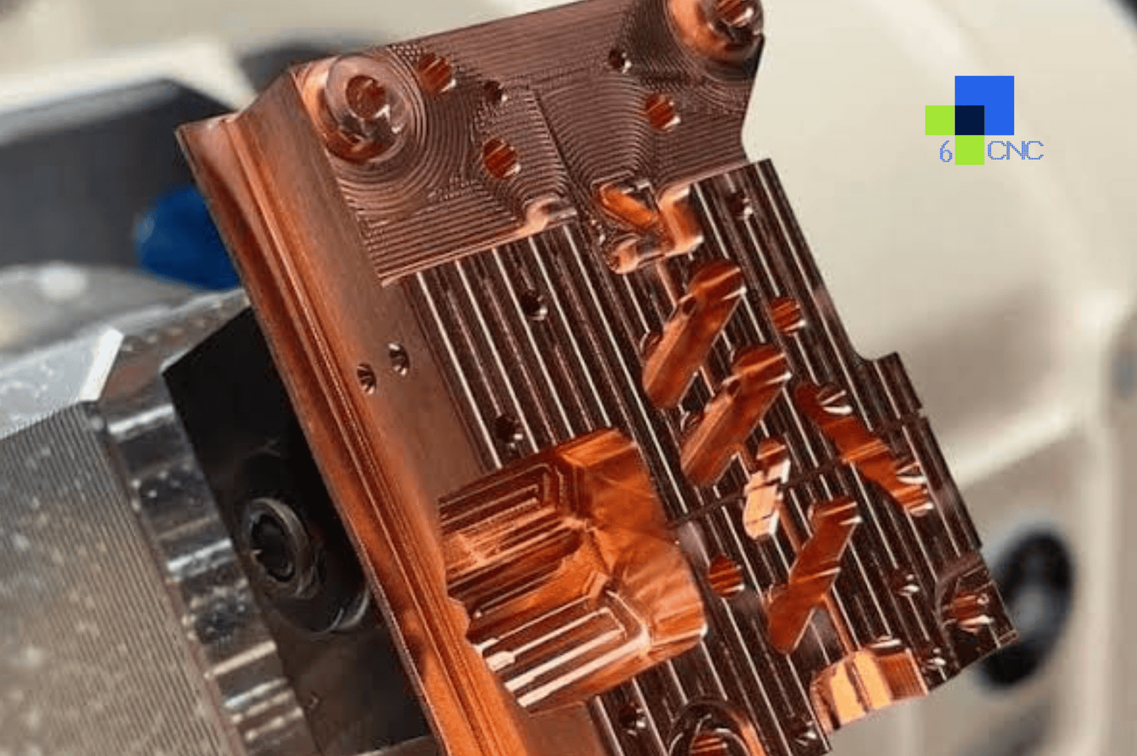 Close-up of a copper alloy CNC machined part with intricate details and conductive features.