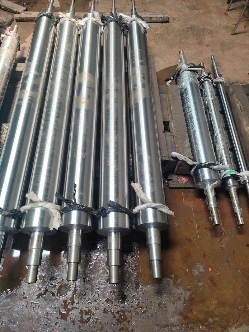 Group of long metal shafts with flanges and stepped ends