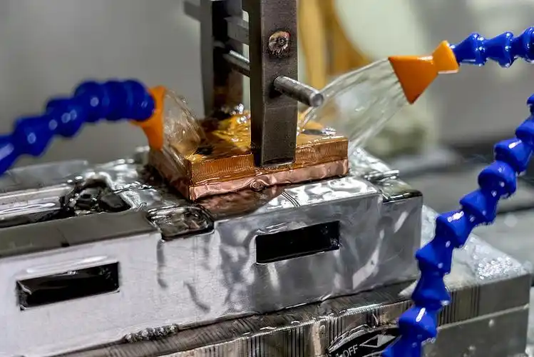 Sinker EDM electrode machining a cavity with dielectric flushing nozzles
